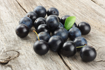 blackthorn berries with green leaf on old wooden table