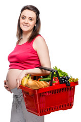Fototapeta na wymiar Young pregnant woman with basket of fruits and vegetables on white background isolated