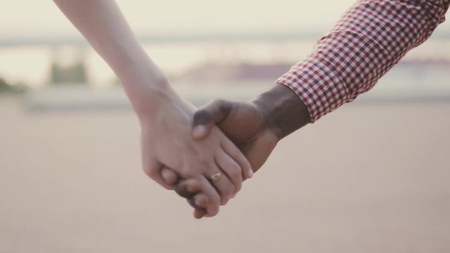 two interracial lovers joining hands