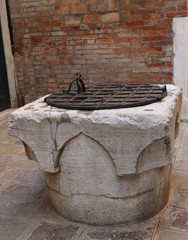 ancient stone well in a square of a European city