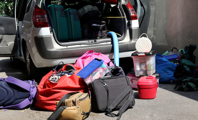 car with many luggage on the ground and in the baggage van befor