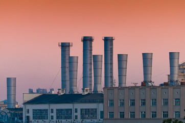 Factory electric company with the red sky. Factory pipes.