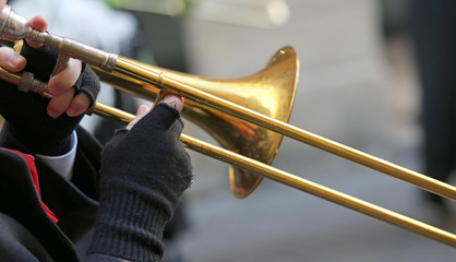 hand of elderly man with gloves playing the trumpet