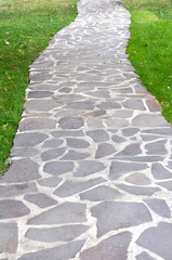 Stone path in the green garden or park
