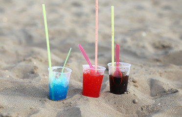 plastic glasses on the beach with sweet syrup called GRANATINA i