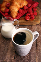 Coffee white cup, croissants on brown wooden background. Breakfa