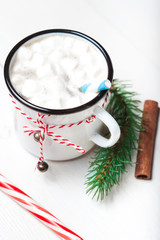 Hot chocolate with marshmallow on white  wooden table. Top view with copy space. Vintage mug of winter cocoa with cinnamon stick. Christmas cozy home concept
