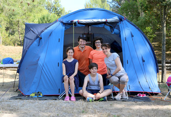 cheerful five-person family with three children with camping ten