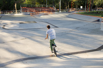 BMX rider training and do tricks in street plaza, bicyxle stunt rider in cocncrete skatepark 