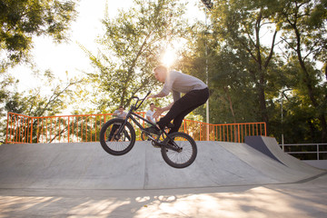 Group of young people with bmx bikes in skate plaza, stunt bicycle riders in skatepark 