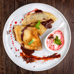 Pancakes with sweet chocolate sauce on a dessert plate