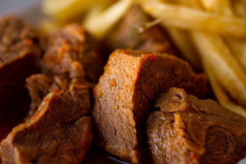 Close-Up Of Delicious Meal Of Beef Stew In Sauce With French Fries