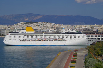 Classic cruise ship or cruiseship liner in port of Piraeus, Athens Greece with skyline in the...