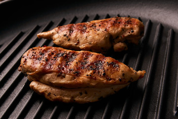Grilled chicken breast fillets on black ribbed cooking pan