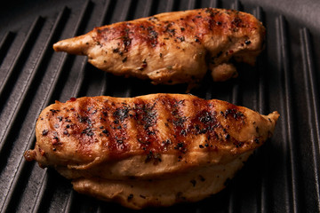 Grilled chicken breast fillets on black ribbed cooking pan