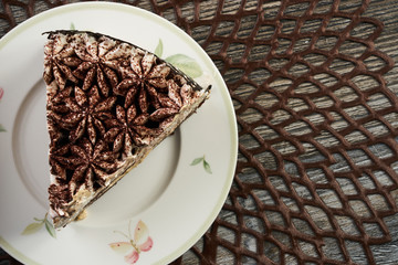 Slice of chocolate cake with biscuit on plate