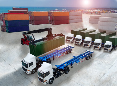 aerial view of loading forklift stacker handling cargo container loading to container trailer in import export logistic zone of port in background
