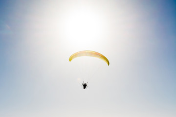 paraglider flying with paramotor on blue sky