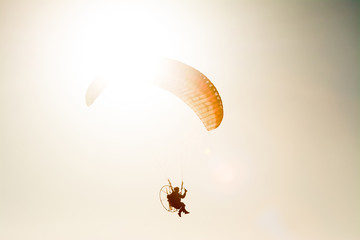 paraglider flying with paramotor on blue sky