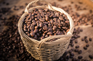 Coffee beans and wooden spoon on sackcloth surface