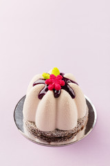 Flower shape mini mousse pastry dessert covered with chocolate velour and decorated with glaze