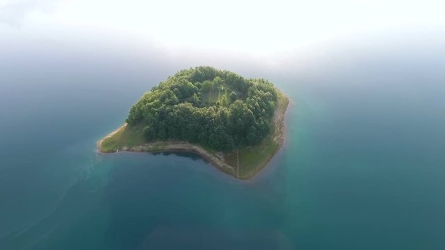 Drone aerial shoot of small island on Ramsko Jezero lake - a tourist destination near Prozor, Bosnia and Herzegovina