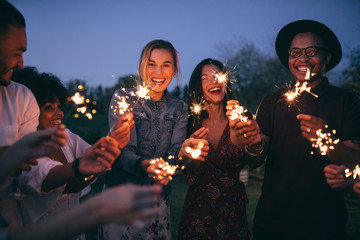 Group of friends enjoying out with sparklers - Powered by Adobe