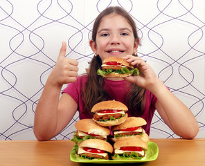 little girl with hamburgers and thumb up