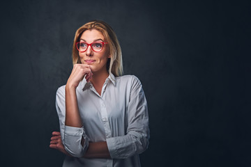 Blond female dressed in a white shirt and red eyeglasses.