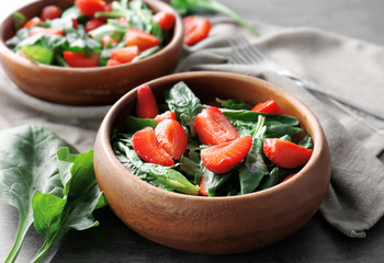 Bowl with strawberry spinach salad on table, closeup