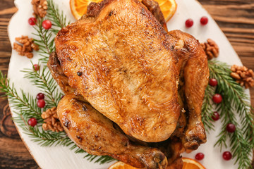 Roasted turkey with orange and fir tree branches on plate