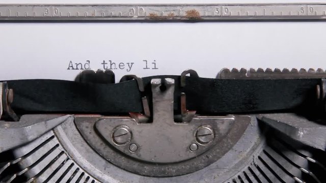 Typing the words -And they lived happily ever after - on a sheet of paper with an old vintage typewriter.

