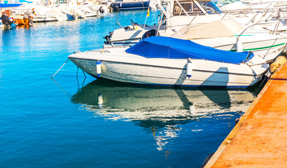 Beautiful luxury yachts and motor boats anchored in the harbor, hot summer day and blue water in...