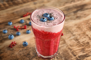 Glass of colorful smoothie with chia seeds on wooden table