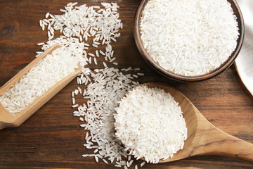 White rice in kitchenware on wooden table