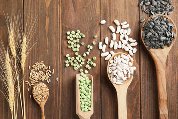 Different grains in kitchenware on wooden background