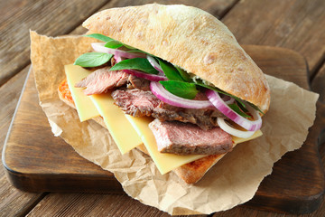 Steak sandwich on wooden board