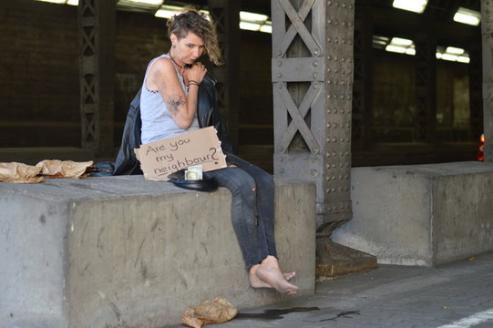 alcohol addicted, homeless woman begging for money holding a sign - are you my neighbor? 