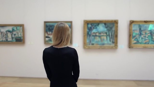 Beautiful Woman Looking at a Picture in a Museum