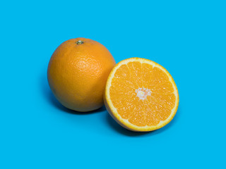 fresh orange with half of orange with shadow isolated on the blue background. orange fruit background