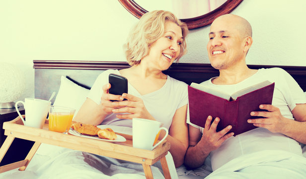 Mature couple having breakfast in bed.