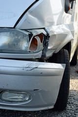 Damaged silver van after accident. Vertical close up image.