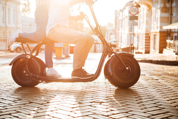 Cropped side view of young african couple rides on motorbike