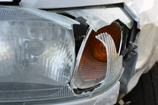 Close up of damaged car headlight after crash. Horizontal image.