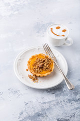 Thanksgiving day concept with homemad pumpkin tartlet, mini pie, on gray stone background. Healthy autumn food, copy space.