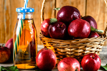 Fresh apple juice in a bottle - drink with red apples on table, organic food and healthy lifestyle concept