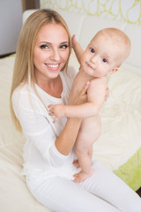 Fototapeta na wymiar Portrait of happy mother with infant son
