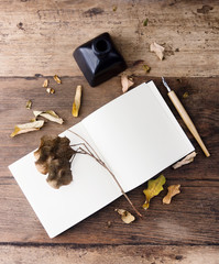 Flat lay empty notebook with autumn leaves on old wooden table. Art mock up. Text space