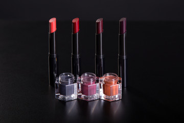 Set of lipsticks and lip glosses on black background