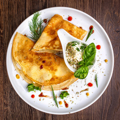 Pancakes with saucer on a wooden background